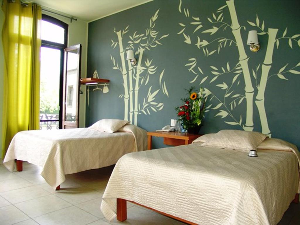 Hotel Plaza Querétaro guest room with two beds, bamboo wall art, and balcony